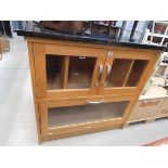 Cabinet with glazed doors and black and granite surface