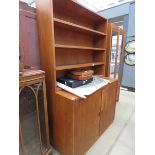 A teak open bookcase with double cupboard space under