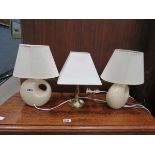 Pair of cream glazed table lamps and a brass lamp