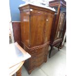 A reproduction mahogany serpentine fronted cabinet with slide and drawers under