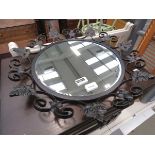 Circular bevelled mirror in wrought iron frame