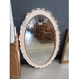 Oval beveled mirror in cream and gilt frame