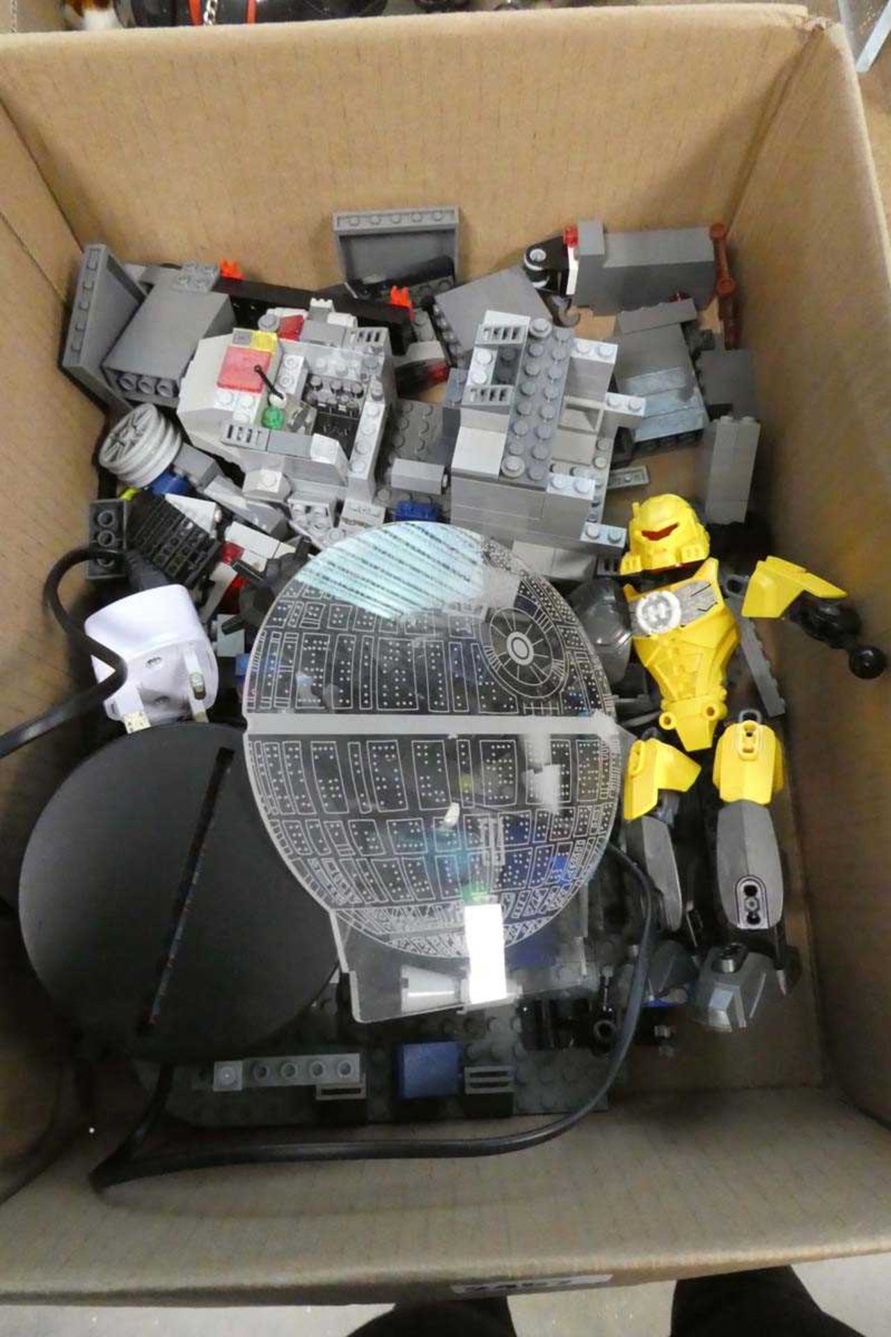 Tray containing various Lego component pieces in grey/black and Lego figure