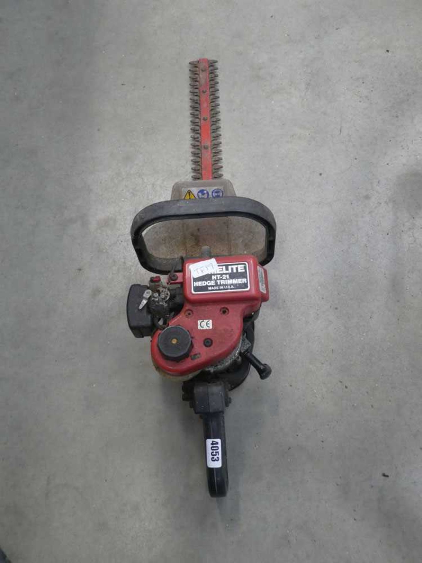 Red petrol powered hedge cutter