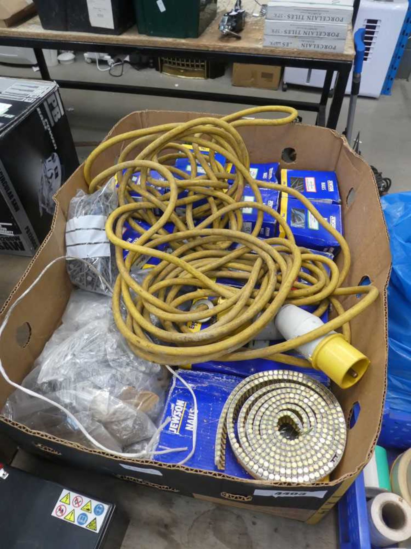 Box containing large quantity of nails and 110V extension cables