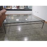 Large glass coffee table on metal supports