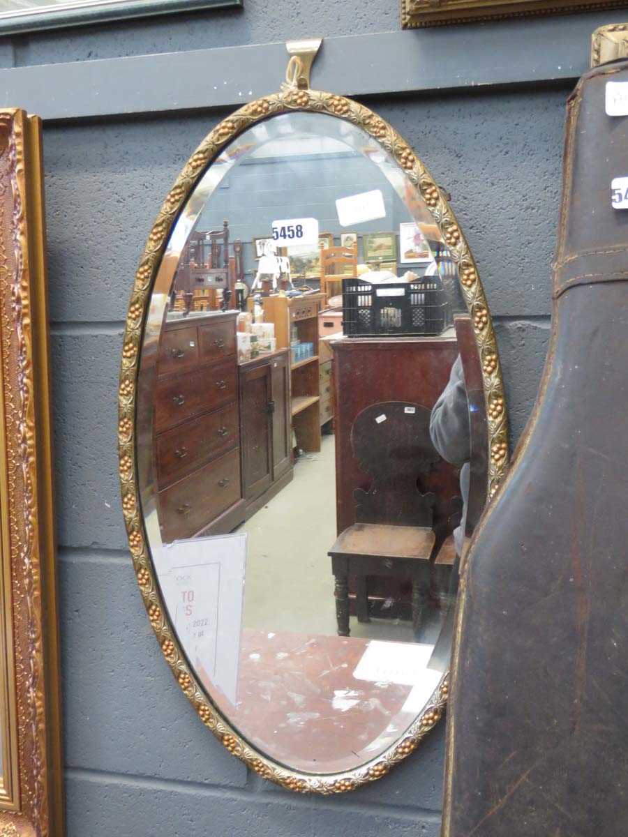 Oval bevelled mirror in floral frame