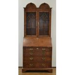 A reproduction walnut Queen Anne-style double-dome bureau bookcase with two glazed doors, fall-front