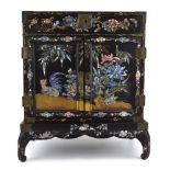 A Chinese Export black lacquered table cabinet, the pair of doors enclosing various drawers, with