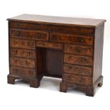 An 18th century walnut kneehole desk with an arrangement of twelve drawers and a single door, c.