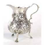 A Georgian silver cream jug of bellied form with c-scroll handle on three hoof feet, maker SM,