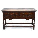 An 18th century oak dresser base, the five drawers with scrolled inlay, on turned front legs