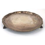 A silver salver of circular form with gadrooned border on three claw and ball feet, Mappin & Webb,