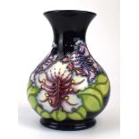 A Moorcroft 'Eric Knowles Club' vase of globular form decorated with stylised lilies on a dark