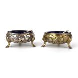 A pair of Edwardian silver salts of bun shaped form with foliate decoration on hoof-type feet, maker