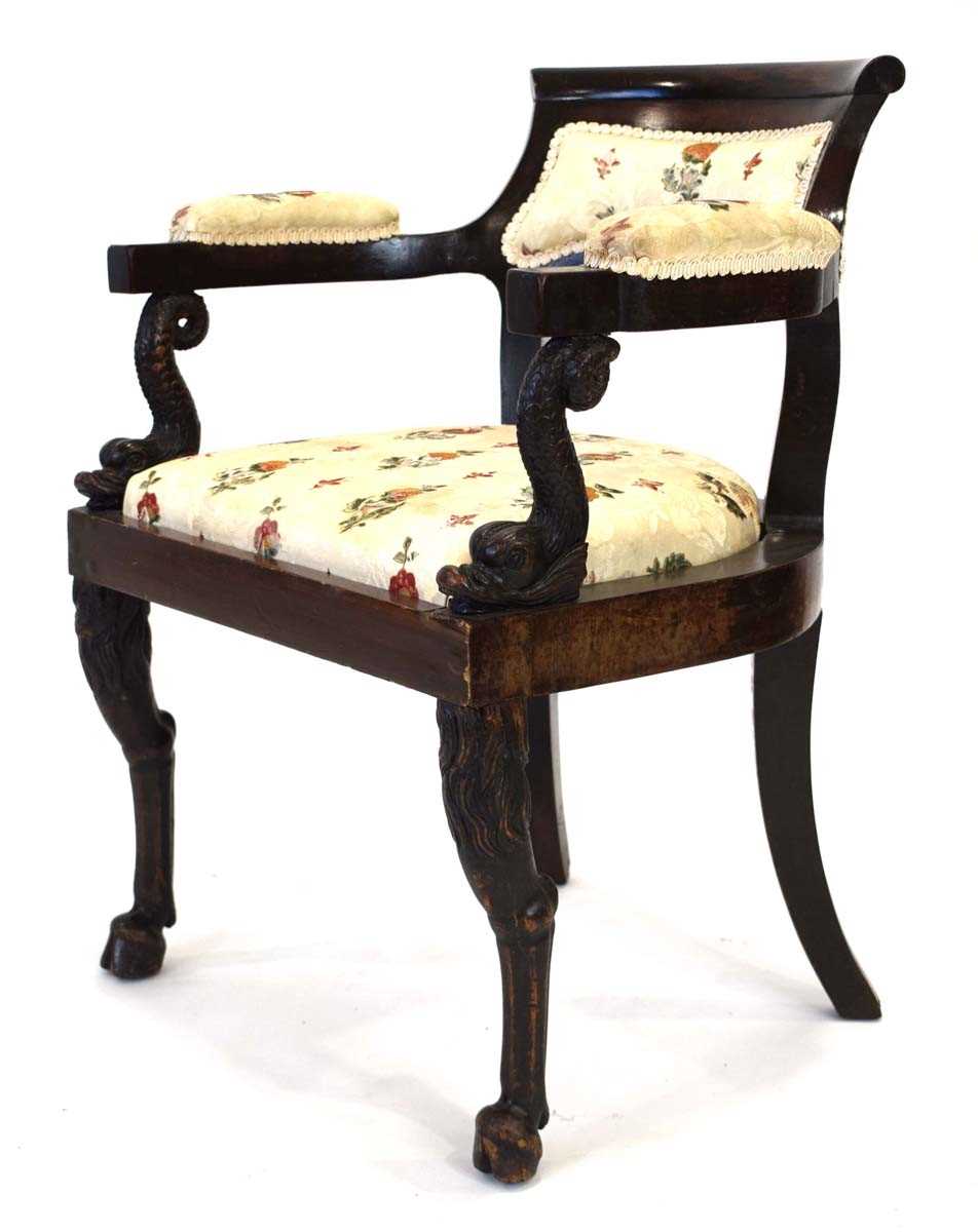 A 19th century mahogany elbow chair with later upholstery, figural dolphin arms and turned legs with