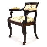 A 19th century mahogany elbow chair with later upholstery, figural dolphin arms and turned legs with