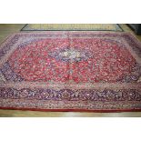 A Persian carpet, richly decorated with a floral red and blue ground, c. 377 x 298 cm