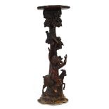 A 19th century and later carved figural torchiere, the column modelled as a cherub riding a