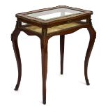 A late 19th/early 20th century bijouterie table, the bevelled glass surface within a walnut,