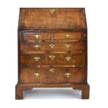 A Georgian walnut and feather crossbanded bureau of small proportions, the fall-front over two short