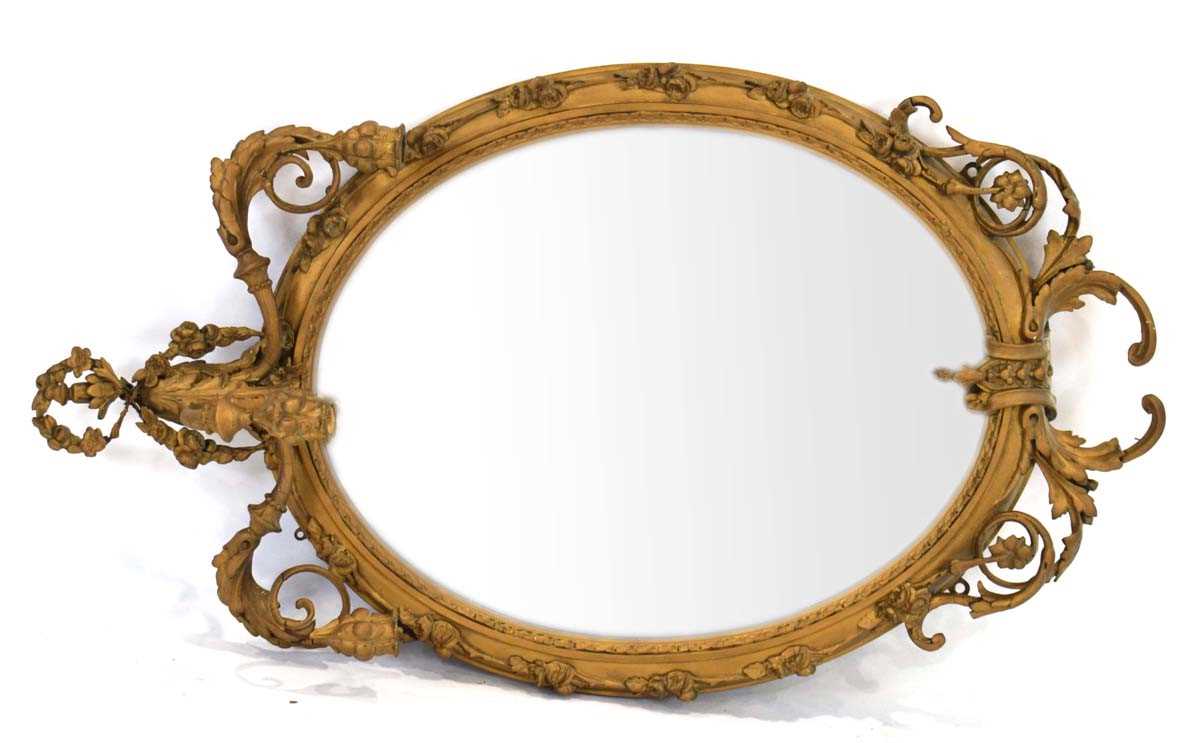 A late 18th/early 19th century giltwood and plaster wall mirror, the oval plate 64 x 50 cm over