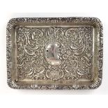 A Victorian silver tray of rectangular form, repousse decorated with stylised flowers and scrolls,