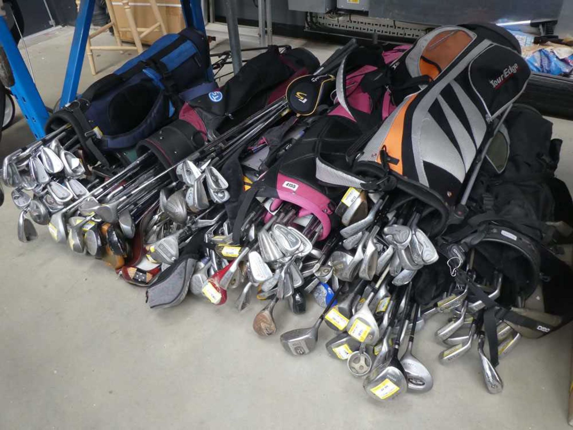 Half an under bay of assorted golf bags and golf clubs