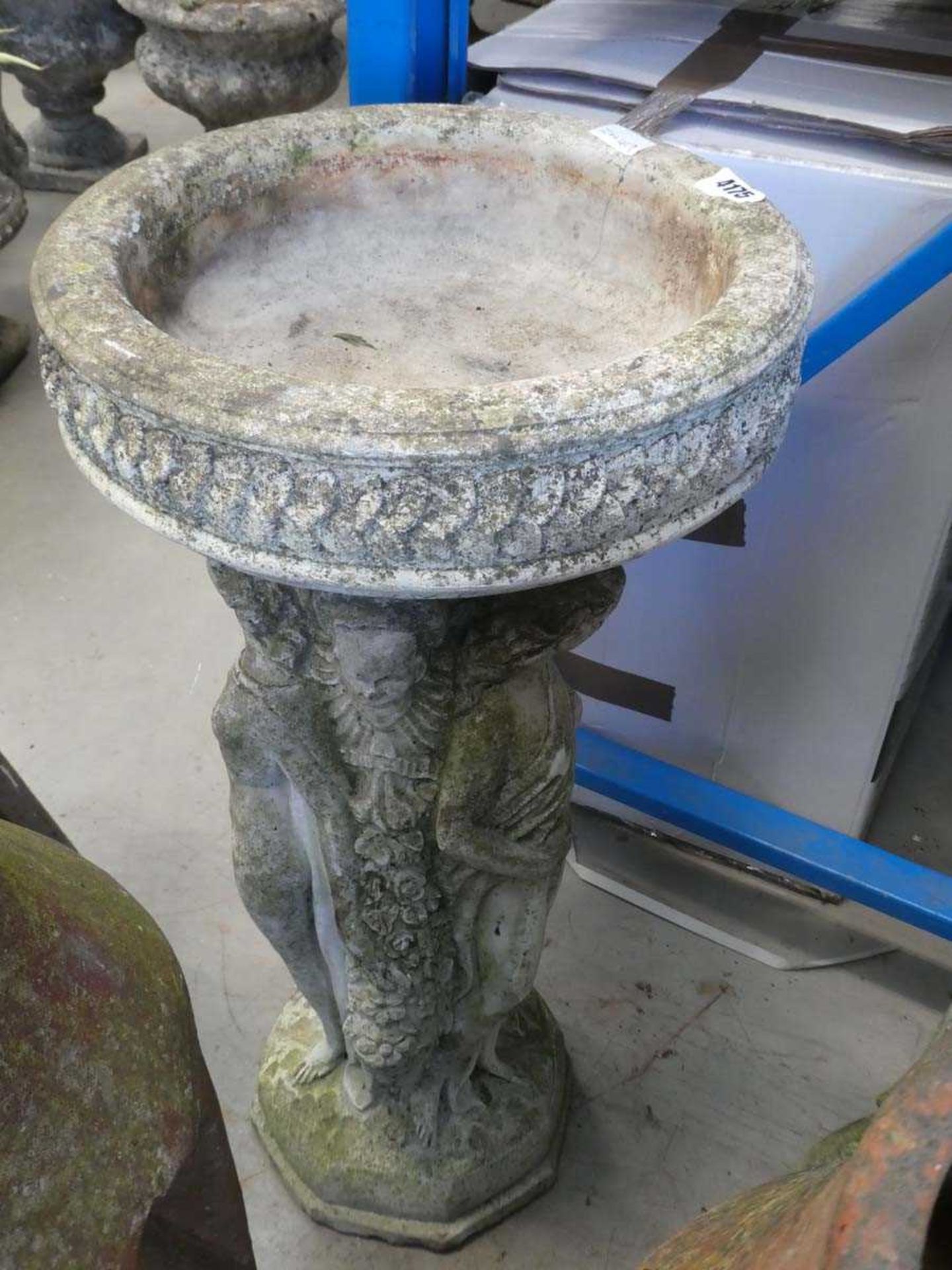 Concrete birdbath with plinth containing statues of ladies