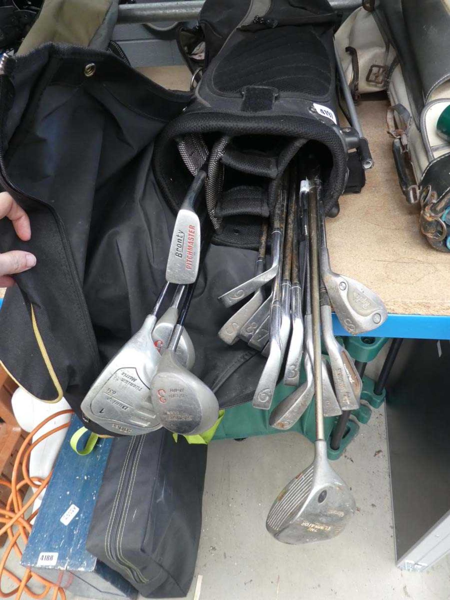 Black golf bag and a quantity of golf clubs plus golf balls