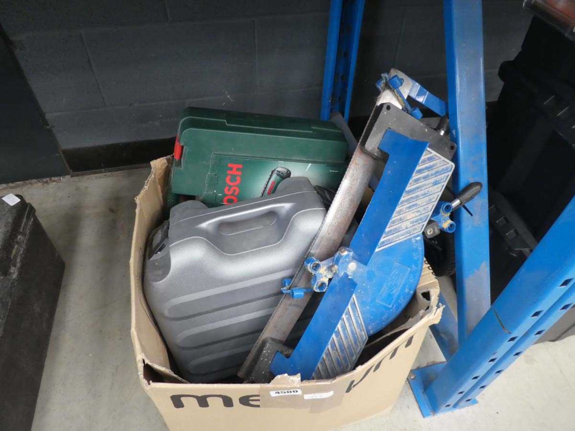 Cardboard box containing mitre saw, drill and various other tools