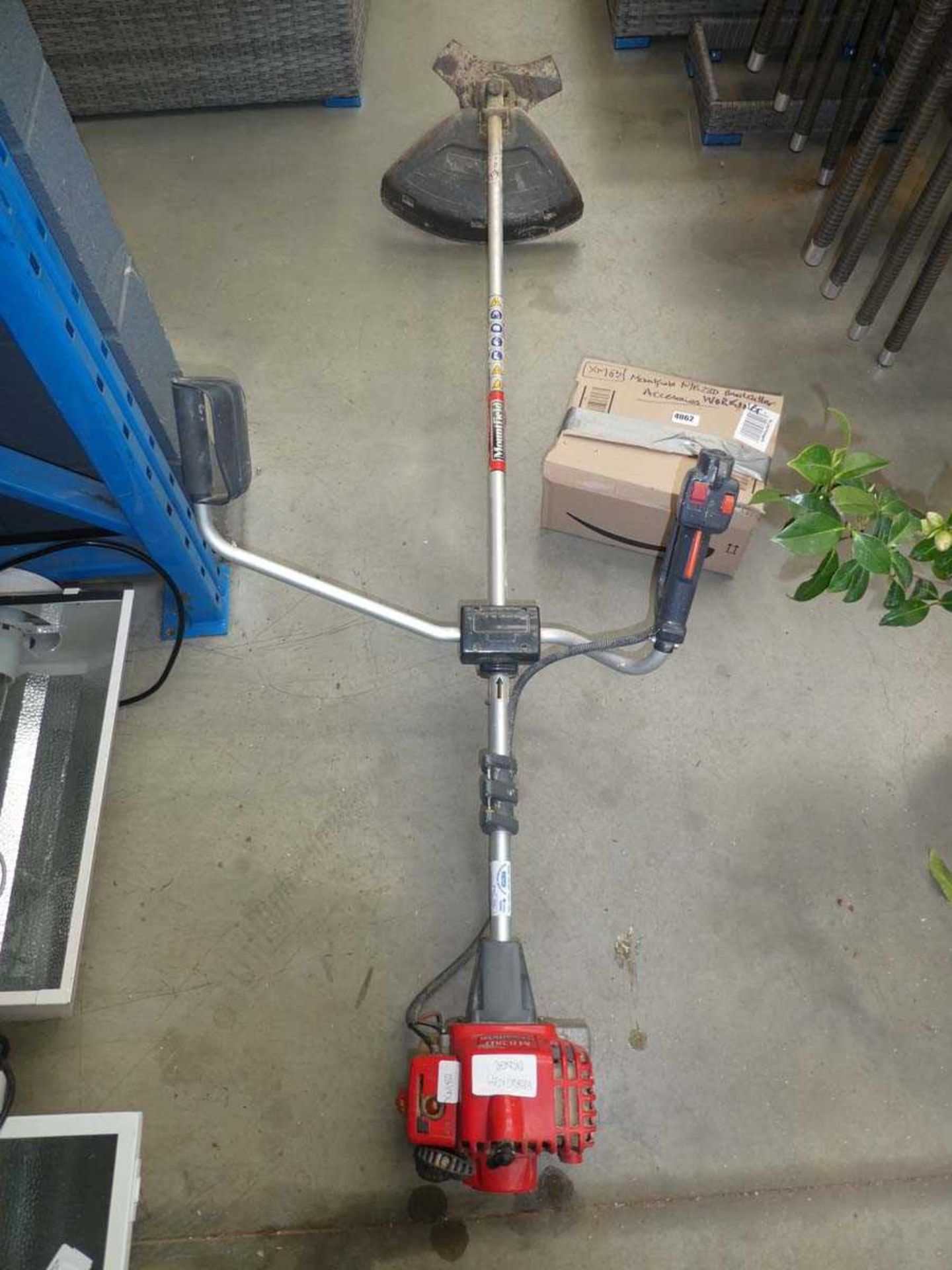 Red petrol powered Mountfield brush cutter with accessories