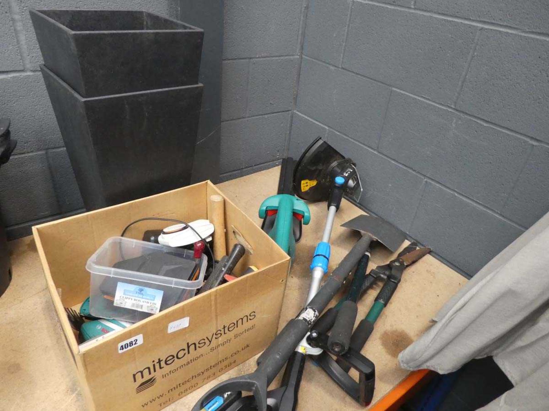 Cardboard box of tools and a Bosch hedge cutter and strimmer
