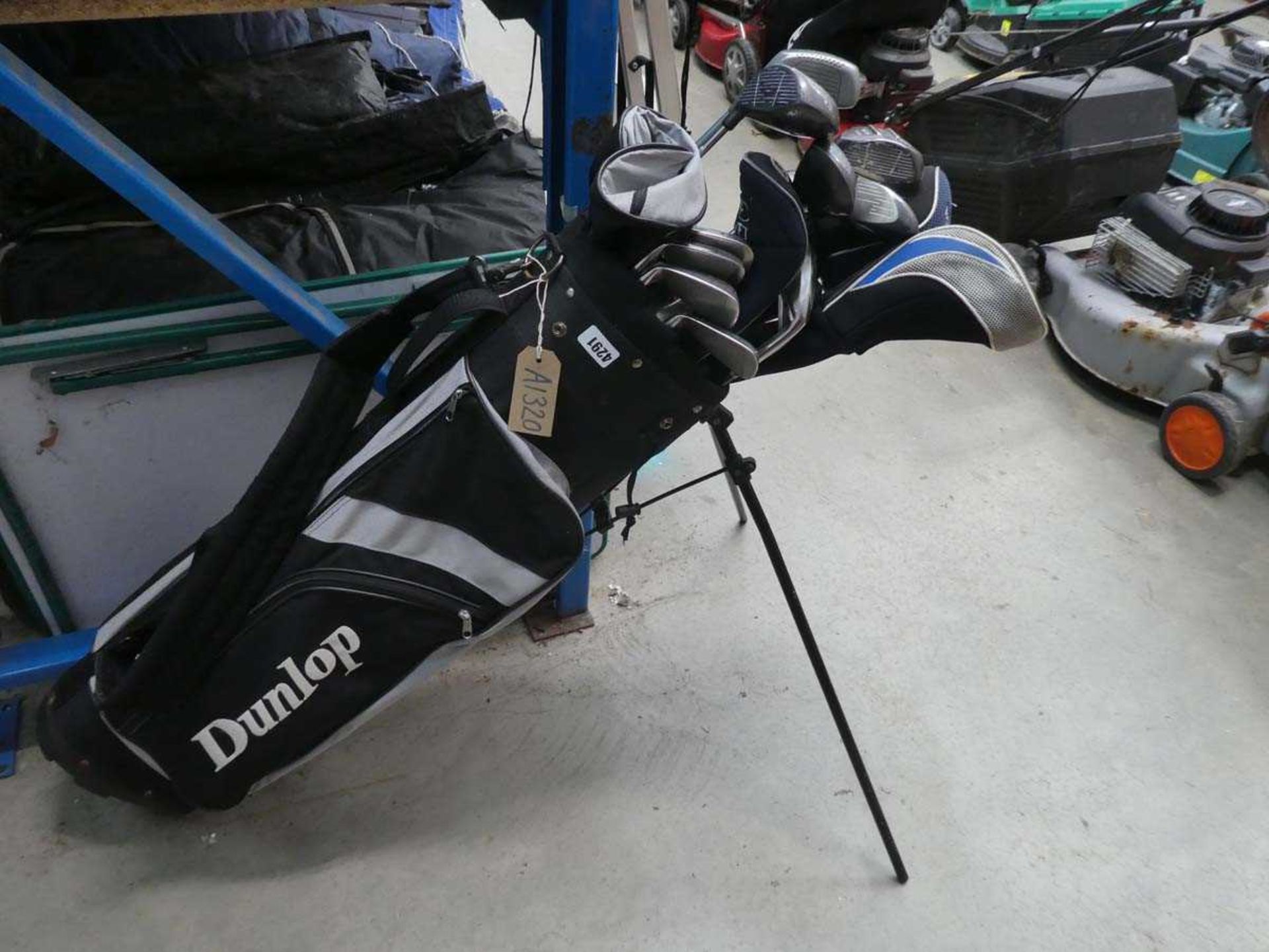 Black and white Dunlop golf bag with a quantity of Mizuno and other golf clubs