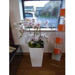 Modern white planter containing artificial orchids