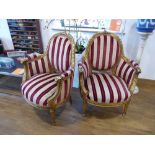 Pair of ornate gilt framed open armchairs with red and beige striped upholstered seats, backs and