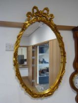 Oval wall mirror in ornate gilt frame
