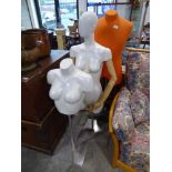 Orange torso mannequin on 3 star base, a female torso mannequin with wooden jointed arms and one