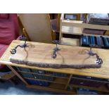 3 wrought metal coat hooks on a rustic plank back board