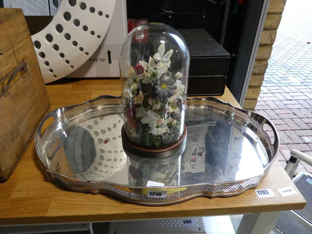 White metal platter and a floral ornament contained within a glass dome stand