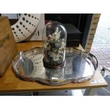White metal platter and a floral ornament contained within a glass dome stand