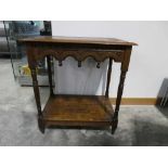 Dark oak side table with carved surface and shelf below