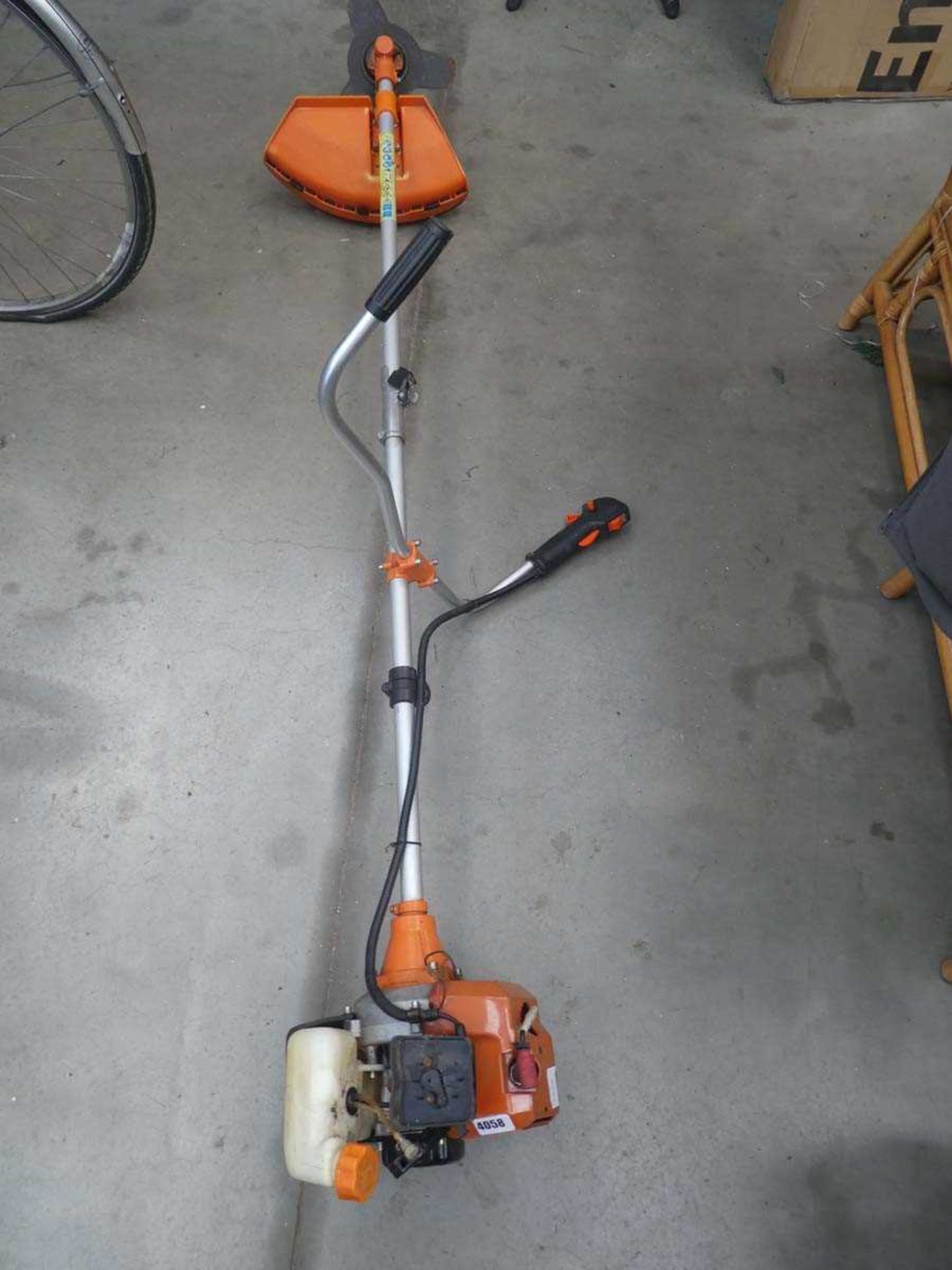 Orange petrol powered strimmer