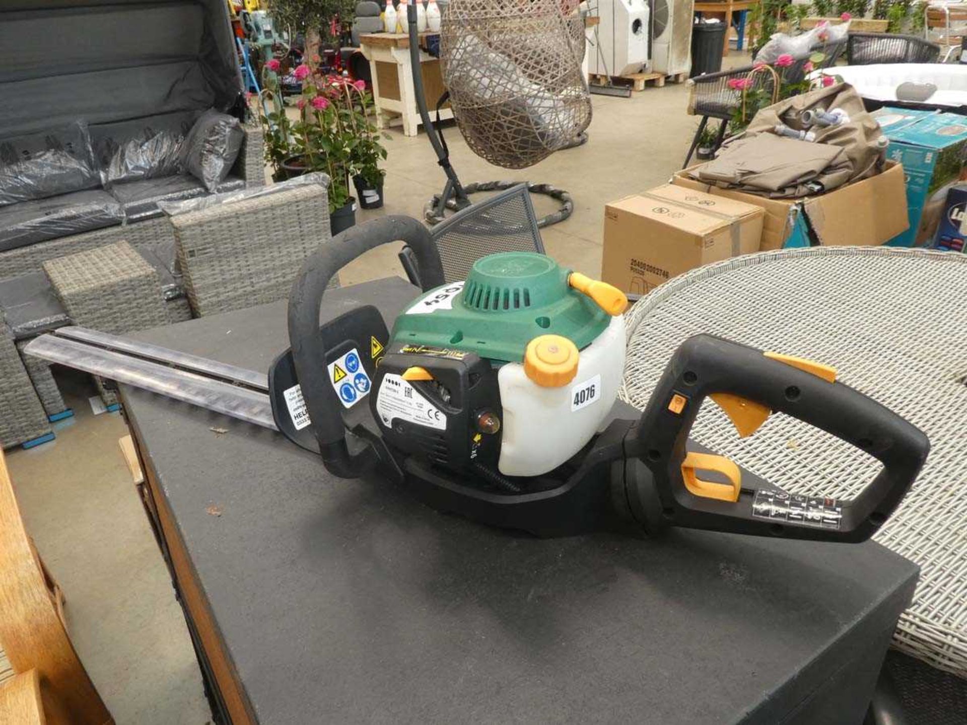 Green petrol powered hedge cutter