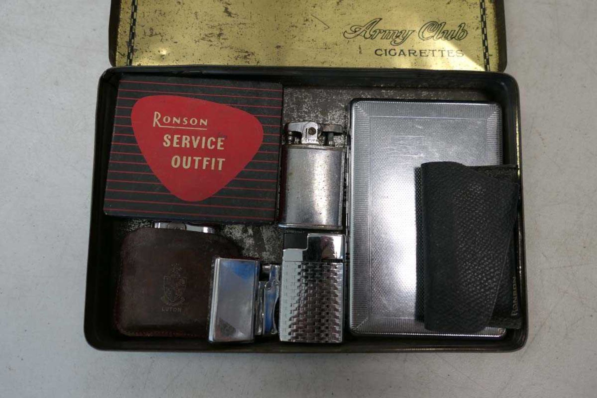 Army Club cigarettes tin containing various lighters inc. Ronson