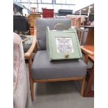 Armchair with exposed frame and grey fabric cushions