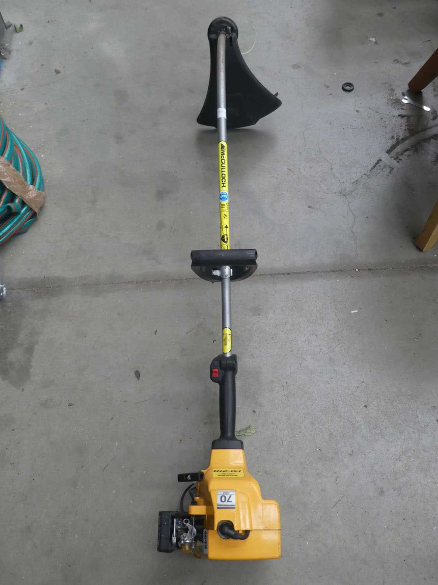 Yellow bent shaft petrol powered strimmer