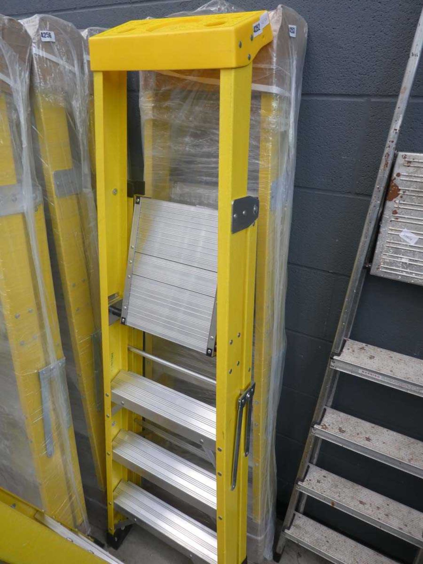 Four tread yellow and silver electrician style step ladder