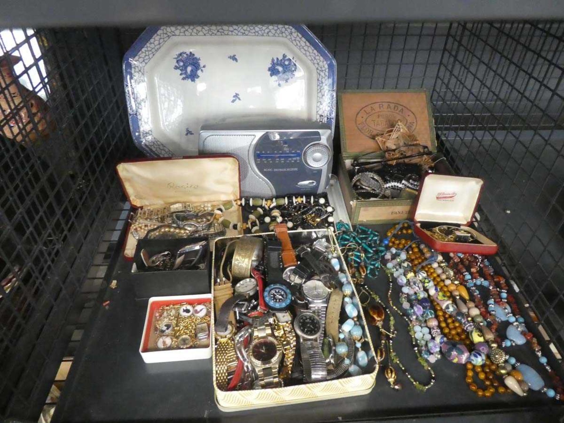 Cage containing costume jewellery, watches, radio and collectible blue and white plate