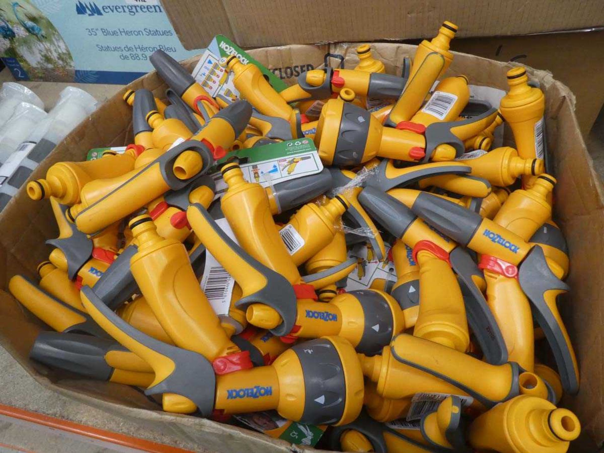 Box of Hozelock yellow water sprayers and hose connectors